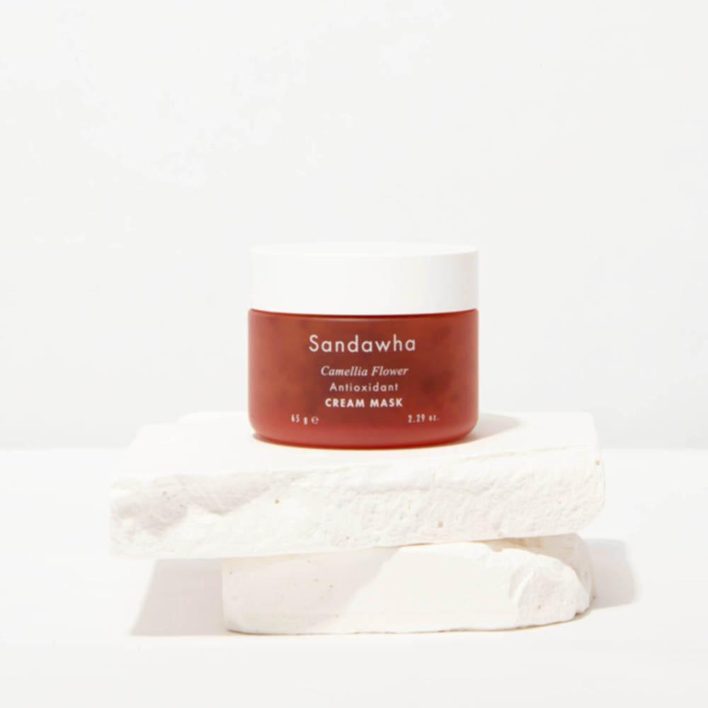 SANDAWHA Camellia Flower Cream Mask 65g, pot crème Sandawha sur fond clair avec pétales et texture crème blanche