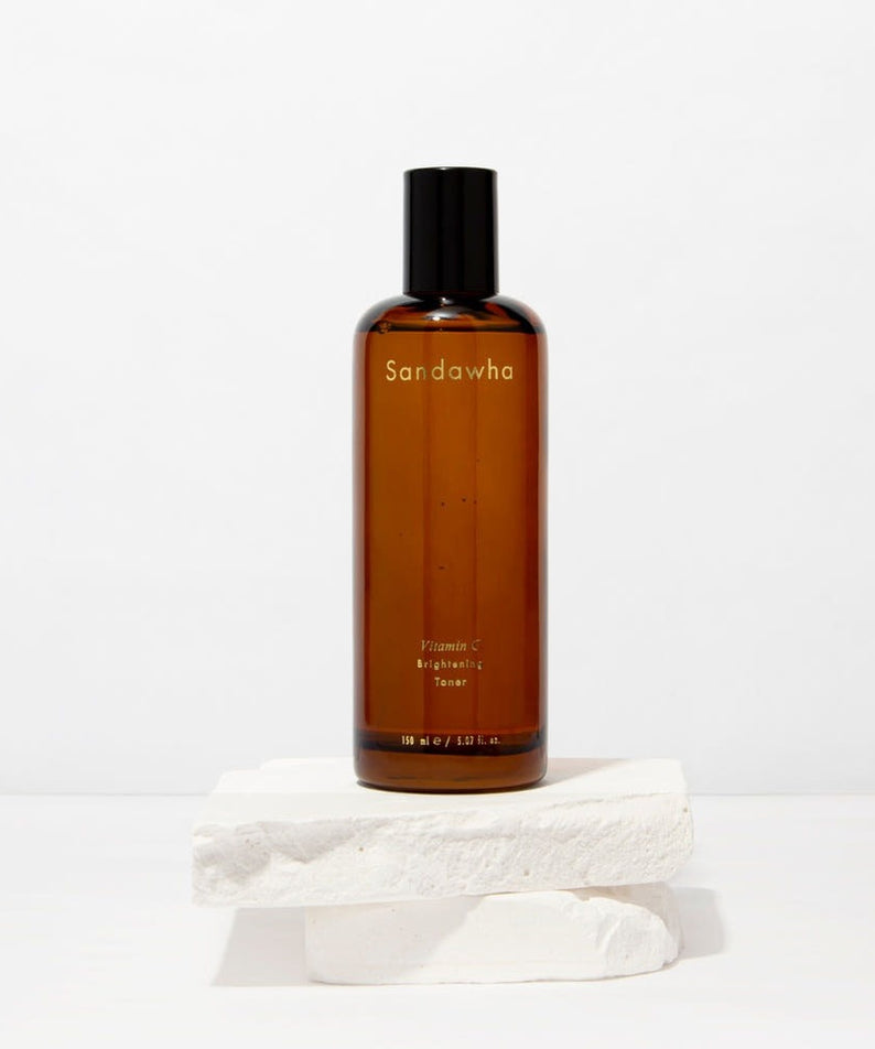 SANDAWHA Vitamin C Whitening Toner 150ml sur fond blanc, bouteille brune élégante, offrant des bienfaits éclaircissants pour la peau.