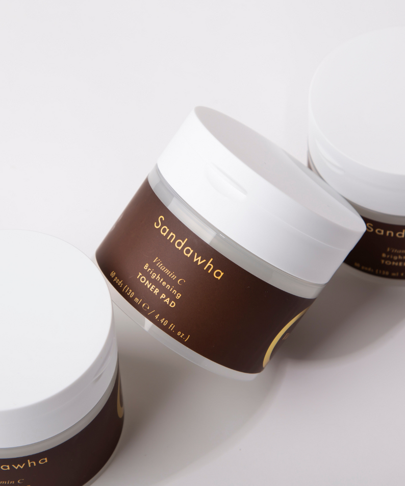 SANDAWHA Vitamin C Whitening Toner pad 60 Sheets avec trois pots sur fond blanc.