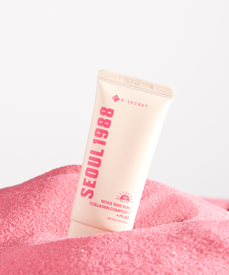 SEOUL 1988  Collagen Sun Lotion 50ml de K-Secret, sur fond blanc, posé sur une texture rose scintillante.