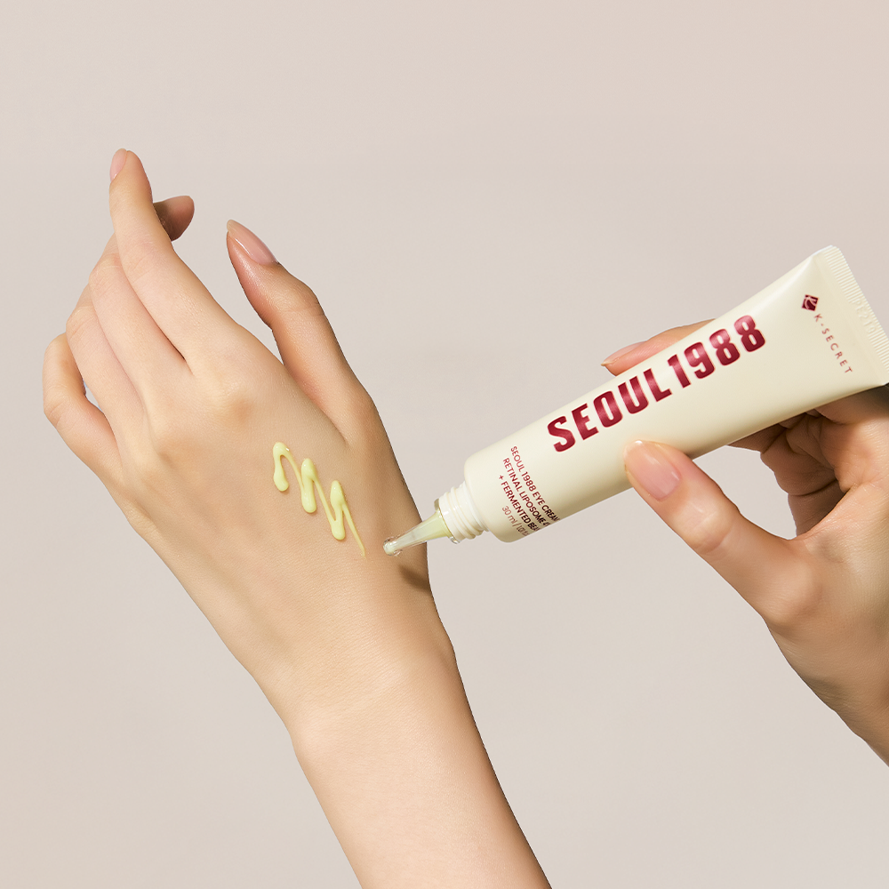SEOUL 1988 Retinal Fermented Soybean Eye Cream 30ml, tube crème autour des yeux, mains en gros plan sur fond beige.