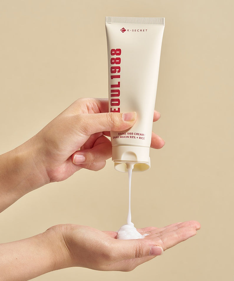 Crème pour le visage SEOUL 1988 Snail 93 Cream appliquée sur les mains avec fond beige.