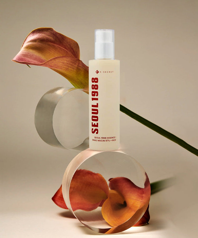 SEOUL 1988 Snail 97 Essence 100ml de marque SEOUL 1988, flacon sur fond beige avec escargots décoratifs.