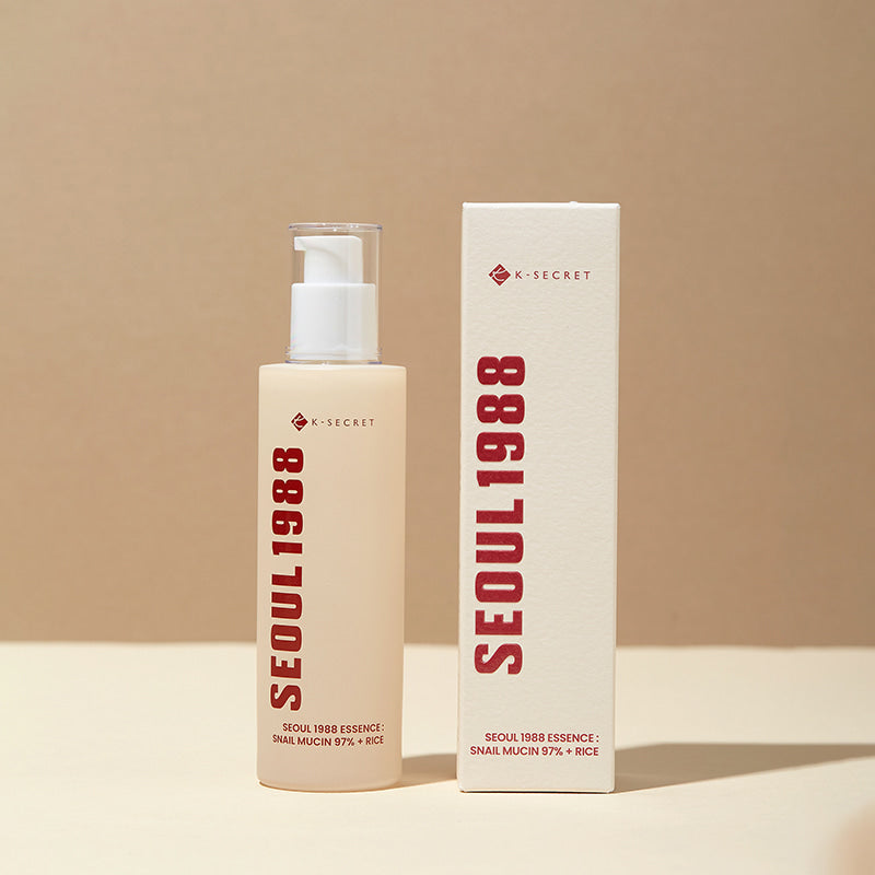 SEOUL 1988 Snail 97 Essence 100ml de K-Secret, flacon blanc et étui beige sur fond crème