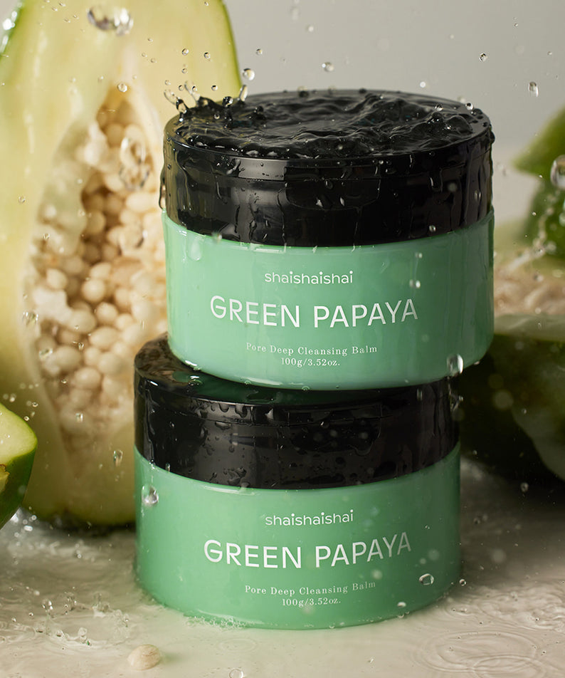 Décris l'image en français : SHAISHAISHAI Green Papaya Pore Deep Cleansing Balm 85ml, pot vert sur fond de papaye verte et eau.