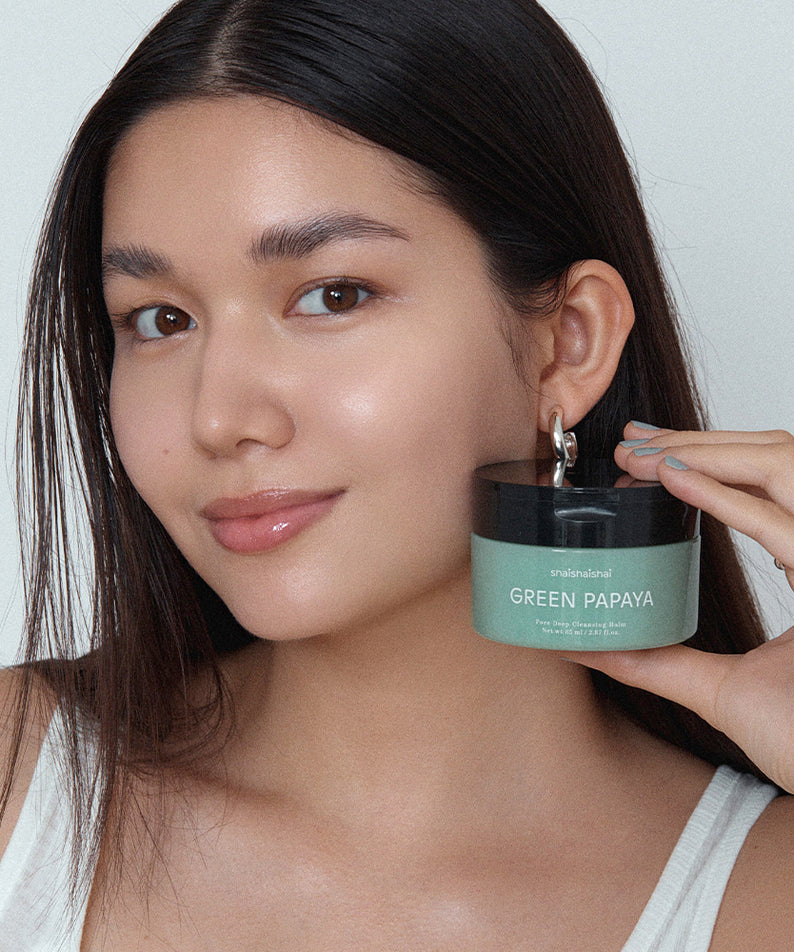 SHAISHAISHAI Green Papaya Pore Deep Cleansing Balm 85ml : femme tenant le baume vert, ambiance beauté sur fond clair.