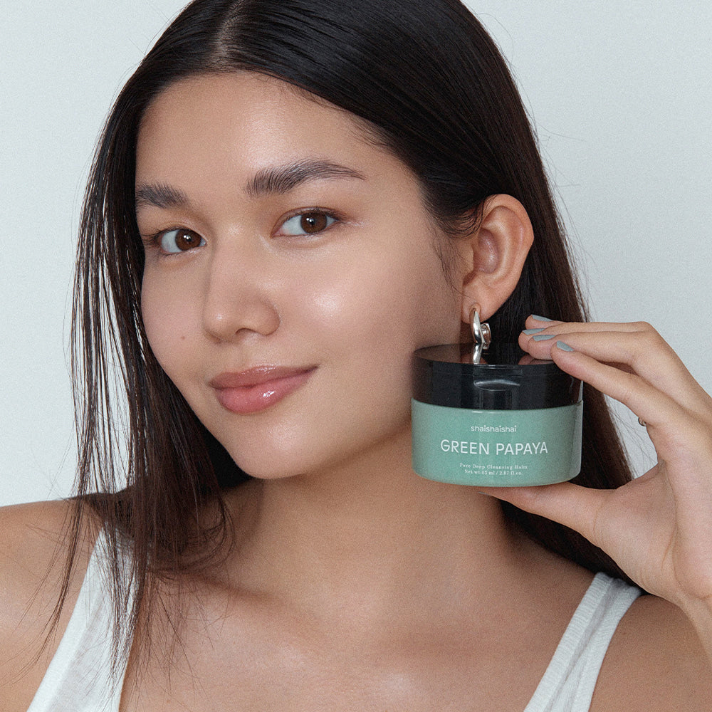 SHAISHAISHAI Green Papaya Pore Deep Cleansing Balm 85ml : femme tenant le baume vert, ambiance beauté sur fond clair.