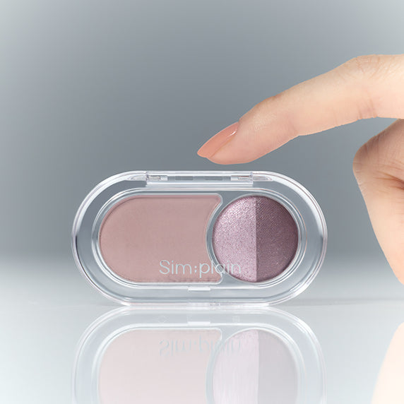 SIM;PLAIN Gleam On Eyes, fard paupières en palette, doigt sur fond gris, gros plan beauté.