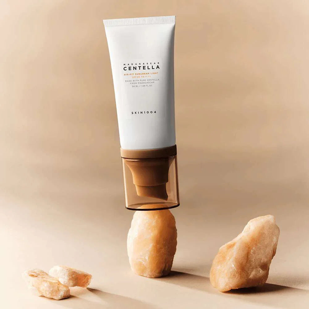 SKIN1004 Madagascar Centella Air-fit Sunscreen Light 50ml, tube crème solaire SKIN1004 sur fond beige, en studio.