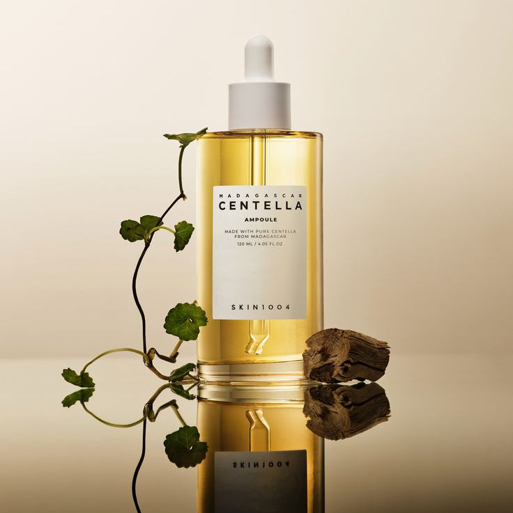 SKIN1004 Madagascar Centella Ampoule 100ml : flacon en verre doré sur fond beige, marque SKIN1004, feuilles et racines illustrées
