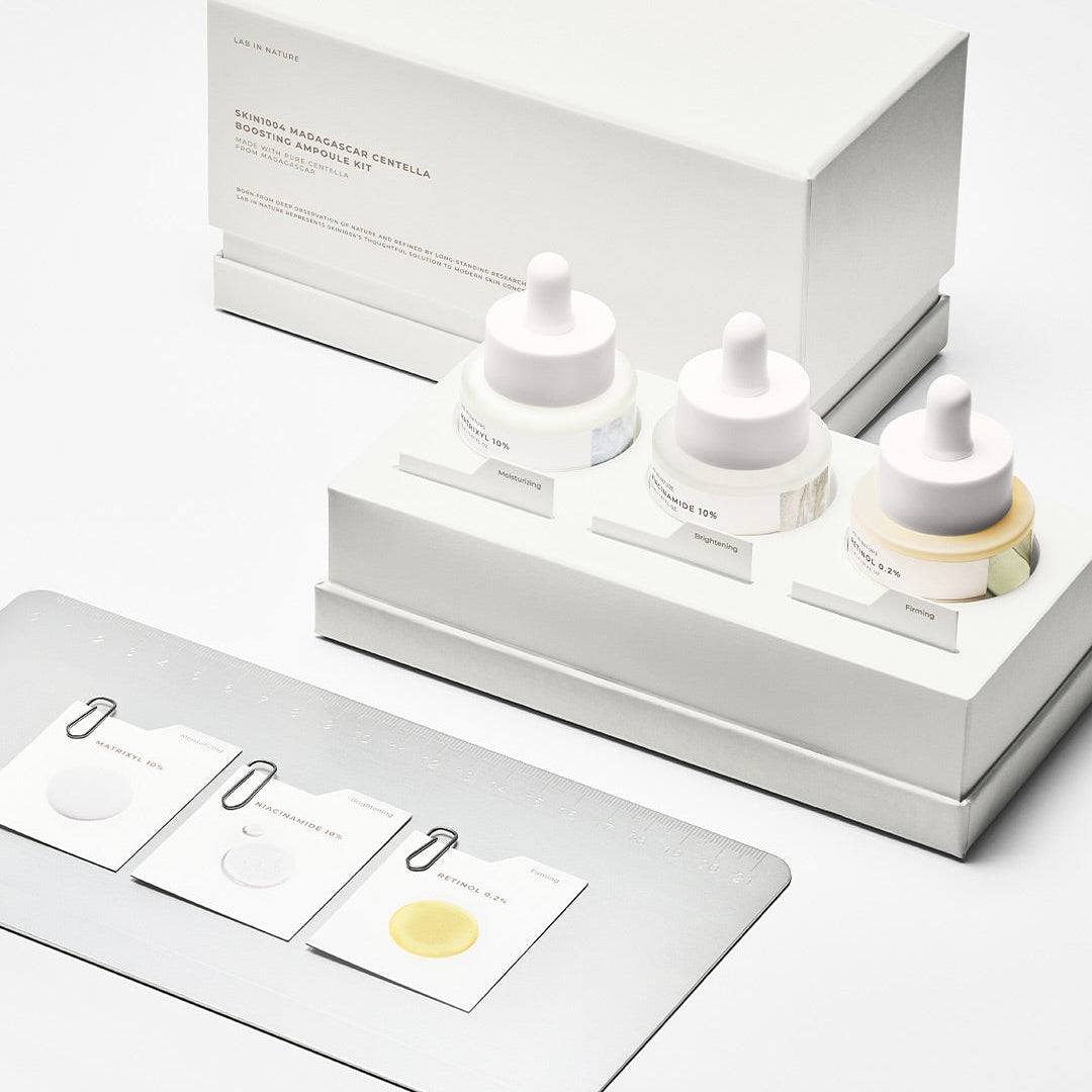 Décris l'image en français : SKIN1004 Madagascar Centella Boosting Ampoule Kit de la marque SKIN1004, coffret d'ampoules blanches sur fond clair.