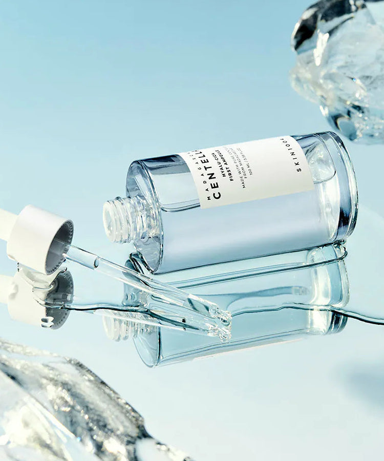 SKIN1004 Madagascar Centella Hyalu-Cica First Ampoule 100ml de la marque SKIN1004, flacon au fond bleu, éclaboussures d’eau