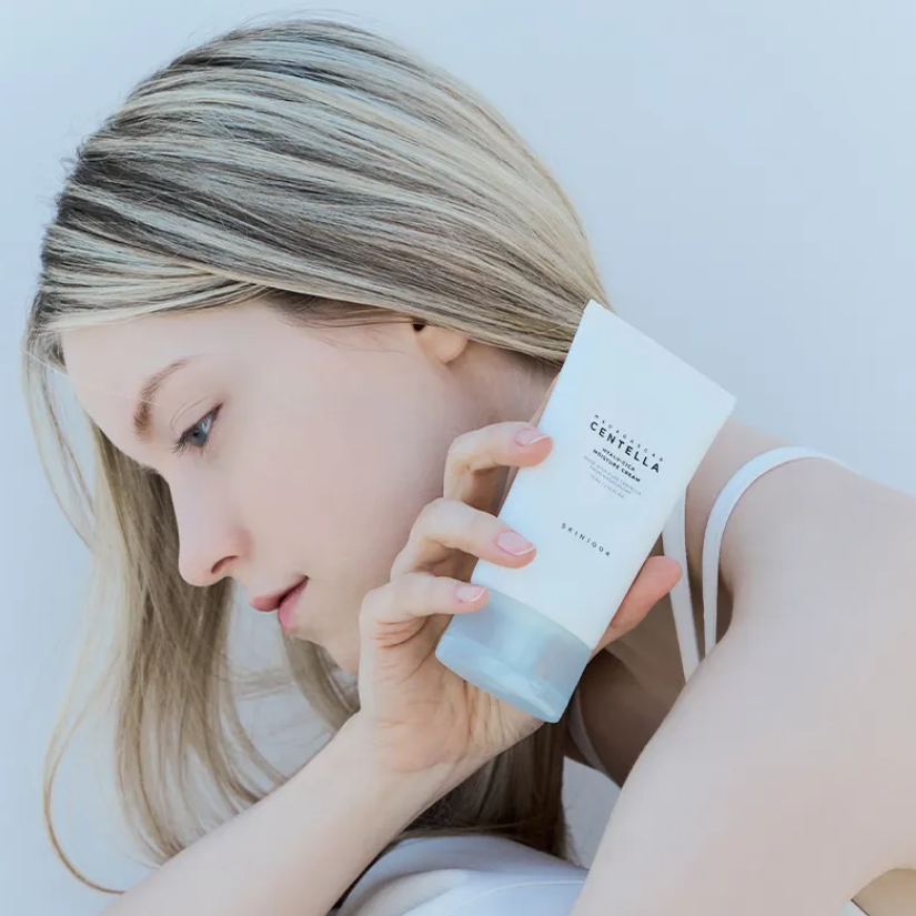 Décris l'image en français : SKIN1004 Madagascar Centella Hyalu-Cica Moisture Cream 75ml de SKIN1004, visage avec pot crème.