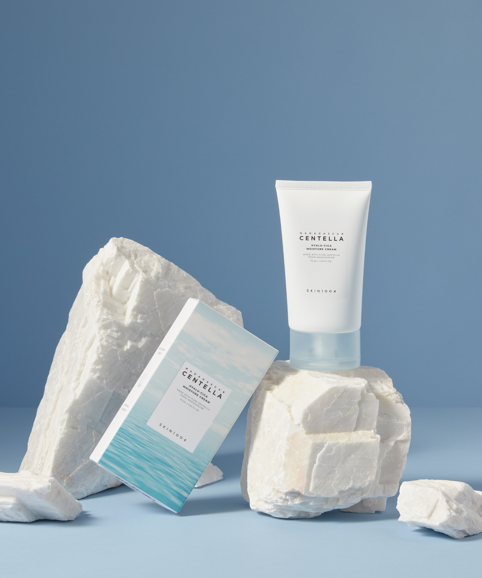 Décris l'image en français: SKIN1004 Madagascar Centella Hyalu-Cica Moisture Cream 75ml, tube blanc SKIN1004 sur fond bleu