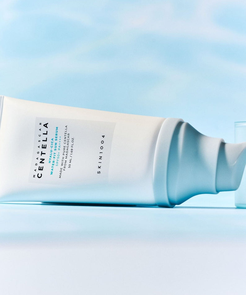 SKIN1004 Madagascar Centella Hyaluronic Acid Water-Fit Sun Serum 50ml de SKIN1004 sur fond bleu, crème solaire texturée.