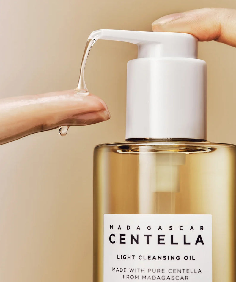 SKIN1004 Madagascar Centella Light Cleansing Oil 200ml, main verse l’huile sur peau, flacon pompe, fond salle de bain