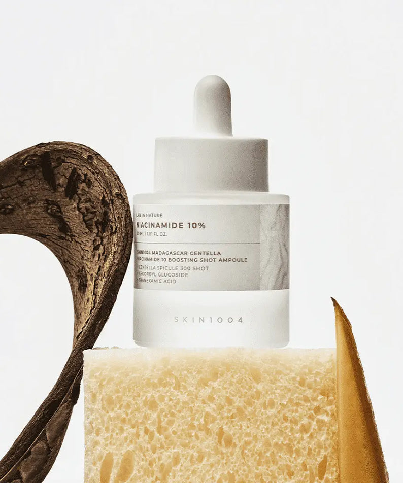 Décris l'image en français : SKIN1004 Madagascar Centella Niacinamide 10 Boosting Shot Ampoule 30ml, flacon sur fond blanc, centella.