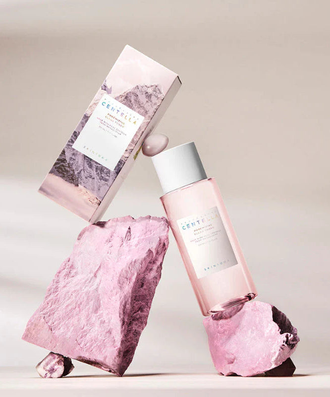 SKIN1004 Madagascar Centella Poremizing Clear Toner 210ml de la marque SKIN1004, flacon rose et textures de centella, fond clair.