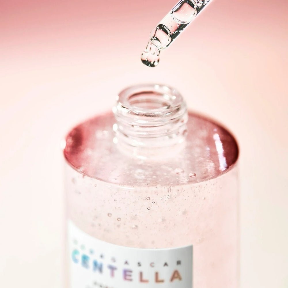 SKIN1004 Madagascar Centella Poremizing Fresh Ampoule 100ml, flacon gouttes de sérum, goutte-pipette sur fond rose.