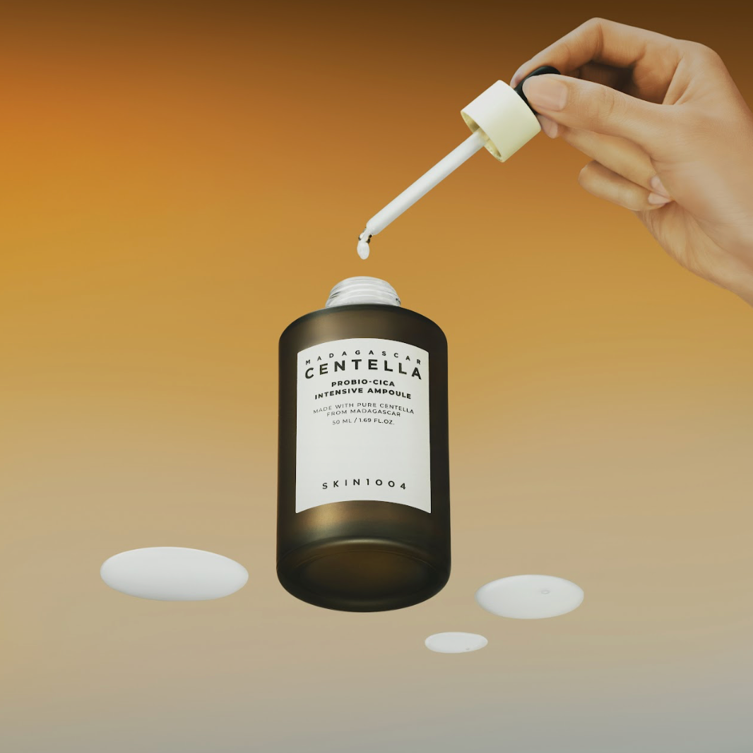 SKIN1004 Madagascar Centella Probio-cica Intensive Ampoule 95ml de la main, pompe verse une goutte sur fond dégradé
