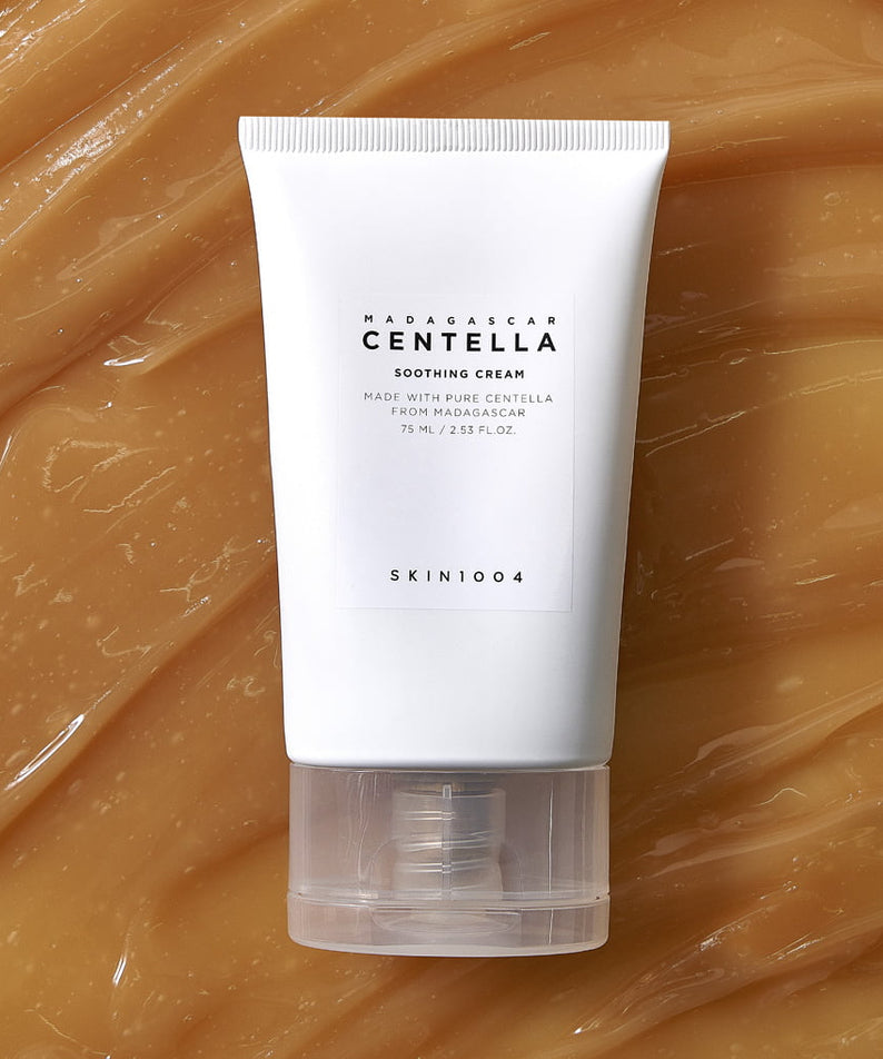 SKIN1004 Madagascar Centella Soothing Cream 75ml, tube sur fond beige avec texture crème, marque SKIN1004, contexte visuel.