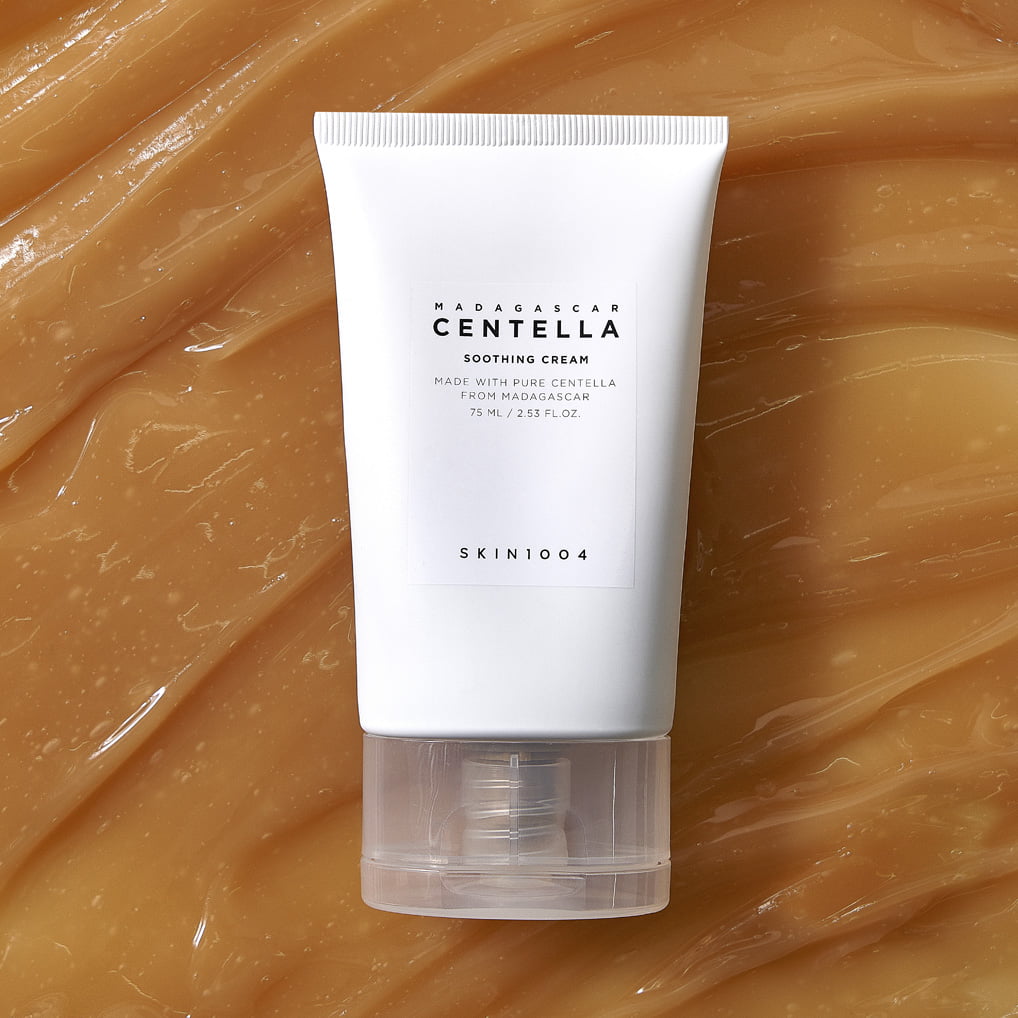 SKIN1004 Madagascar Centella Soothing Cream 75ml, tube sur fond beige avec texture crème, marque SKIN1004, contexte visuel.
