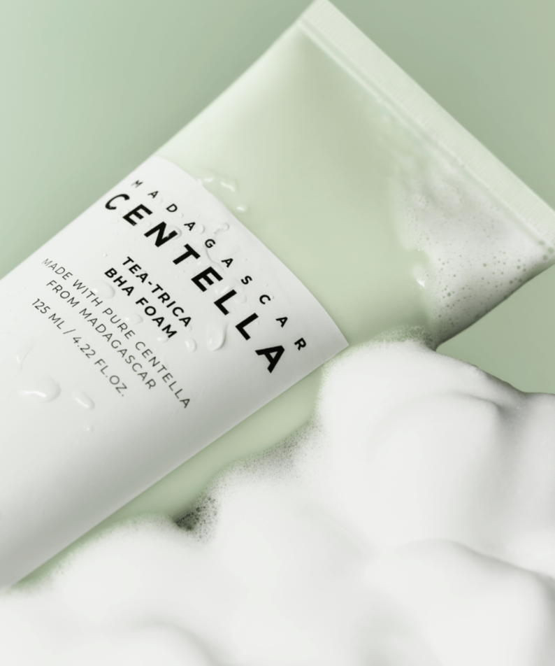 SKIN1004 Madagascar Centella Tea-trica BHA Foam 125ml, tube SKIN1004 sur mousse blanche, fond vert clair.