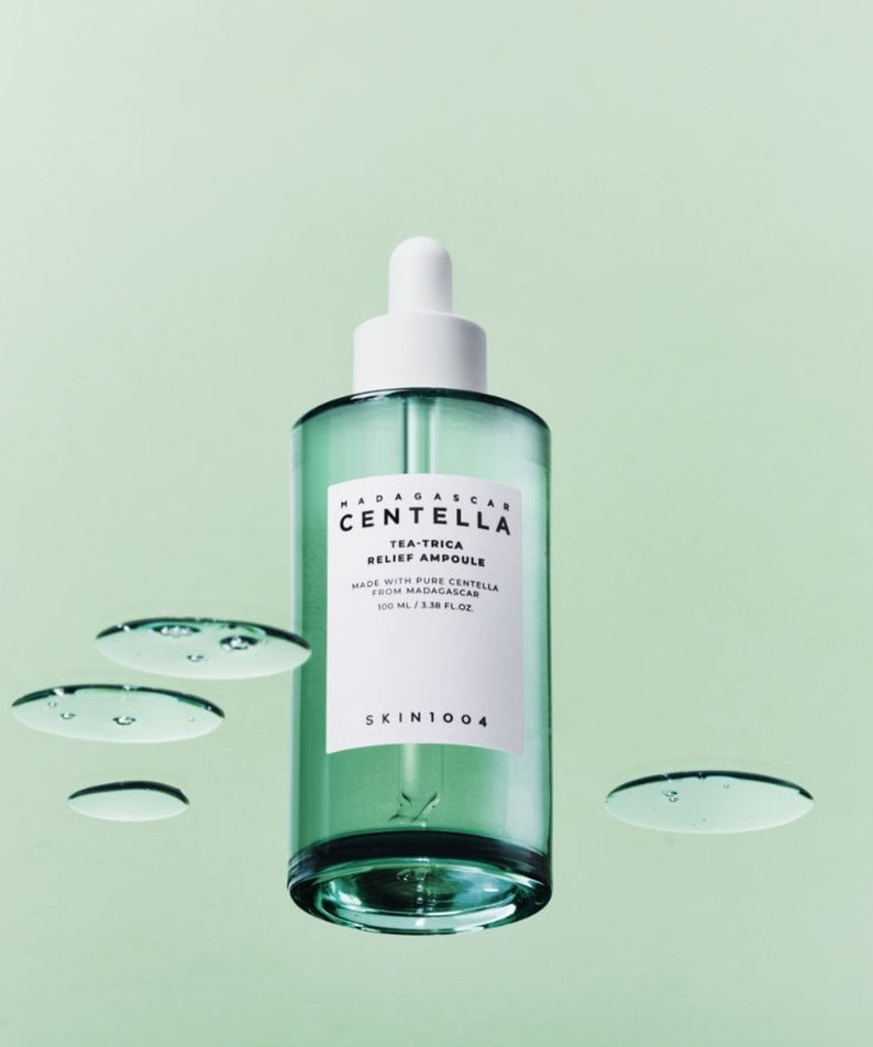 SKIN1004 Madagascar Centella Tea-trica Relief Ampoule 100ml de SKIN1004, flacon vert sur fond clair avec gouttes d’eau