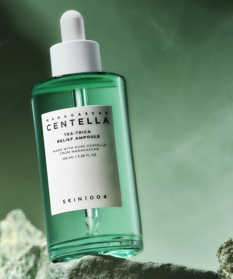 SKIN1004 Madagascar Centella Tea-trica Relief Ampoule 100ml, bouteille verte SKIN1004 sur fond vert, ambiance spa