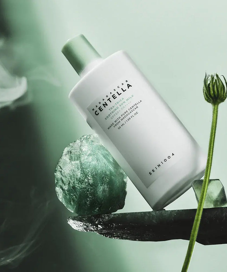 SKIN1004 Madagascar Centella Tea-trica Soothing Sun Milk 50ml : photo produit SKIN1004, fond vert, goutte et plante centella