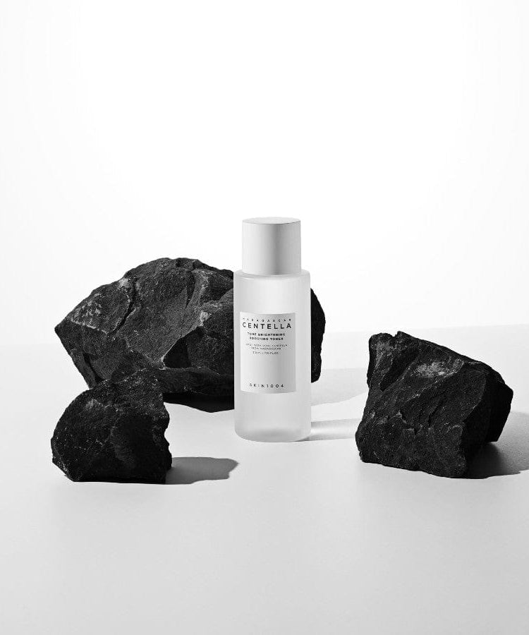 SKIN1004 Madagascar Centella Tone Brightening Boosting Toner 210ml, bouteille sur pierre noire, contexte beauté en studio