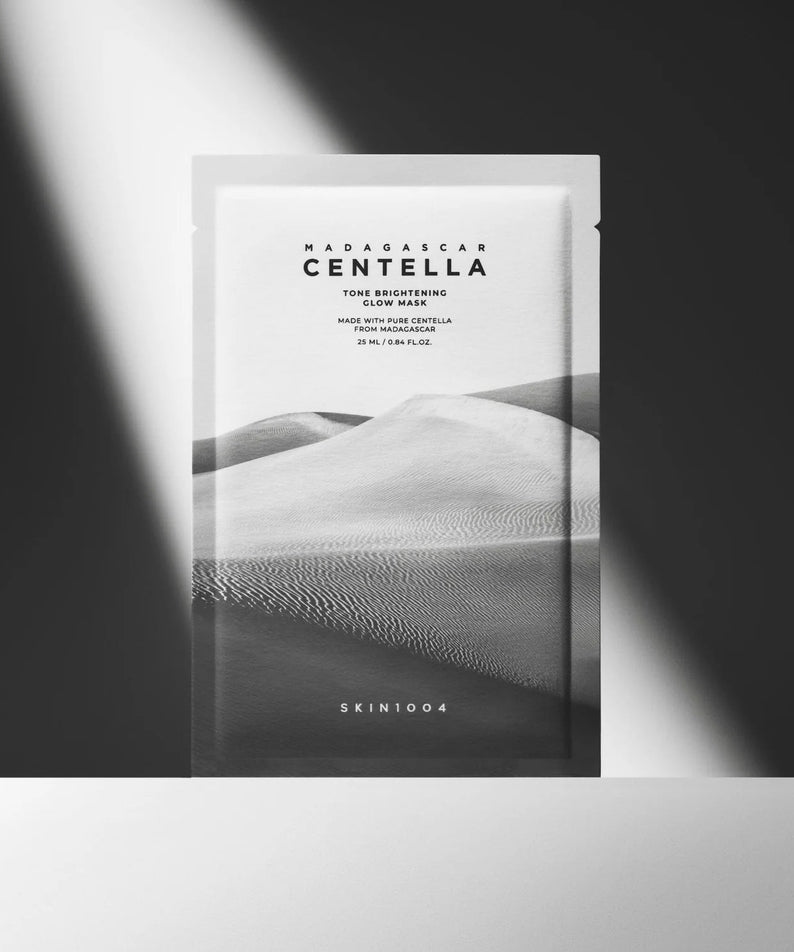 Masque SKIN1004 Madagascar Centella Tone Brightening Glow 25ml [5 sheets] sur fond sombre, mettant en valeur le design élégant.