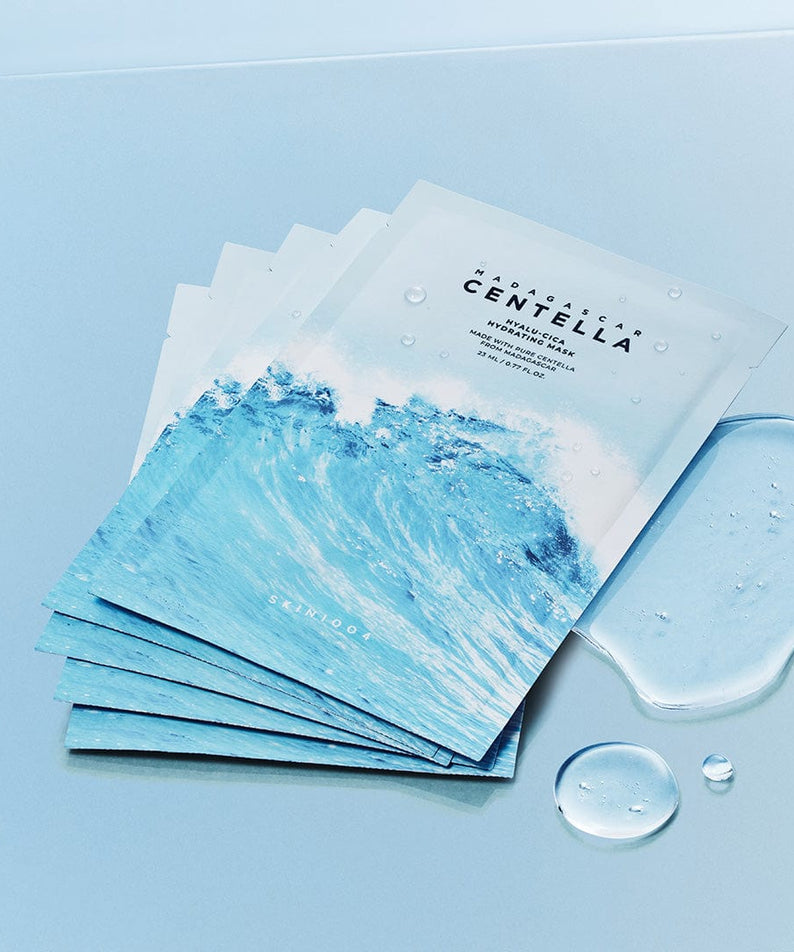 Masque hydratant SKIN1004 Madagascar Centella Hyalu-Cica Acid 23ml [5 sheets] sur fond bleu avec éclaboussures d'eau.