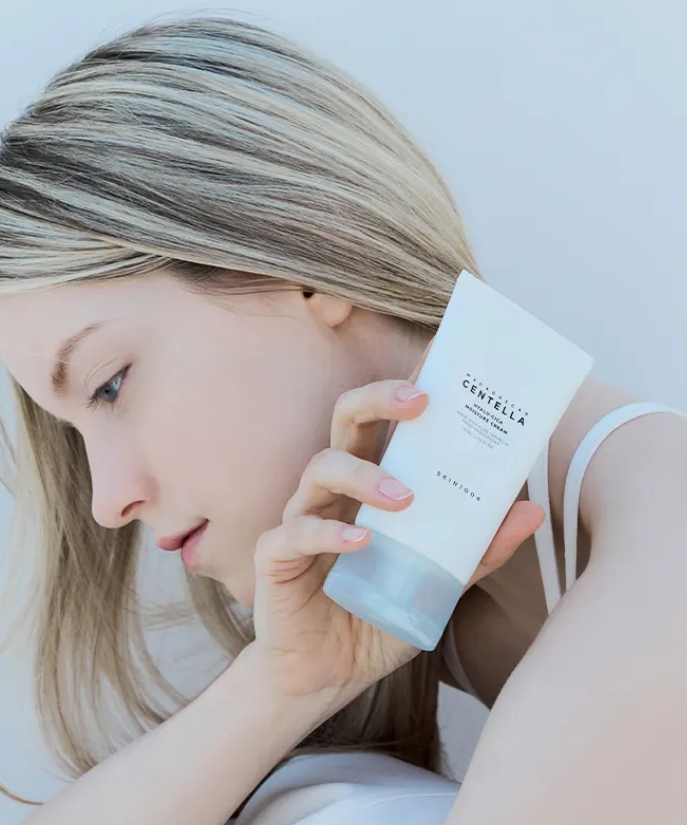 Femme tenant SKIN1004 Madagascar Centella Hyalu-Cica Moisture Cream 75ml, soin de visage hydratant et apaisant.
