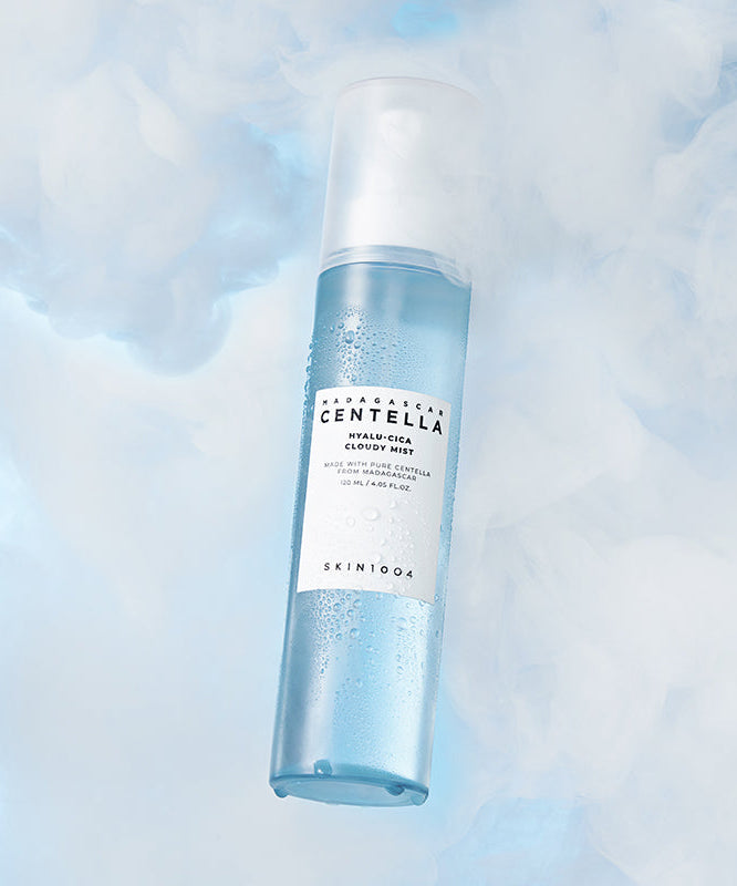 Vaporisateur 120ml SKIN1004 Madagascar Centella Hyaluronic Acid Cloudy Mist sur fond nuageux bleu, soin hydratant visage revitalisant.