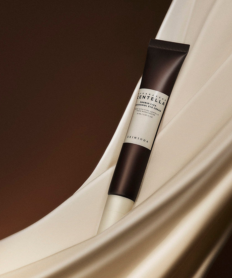 SKIN1004 Madagascar Centella Probio-cica Bakuchiol Eye Cream 20ml sur une chaise en beige élégante, crème contour des yeux.