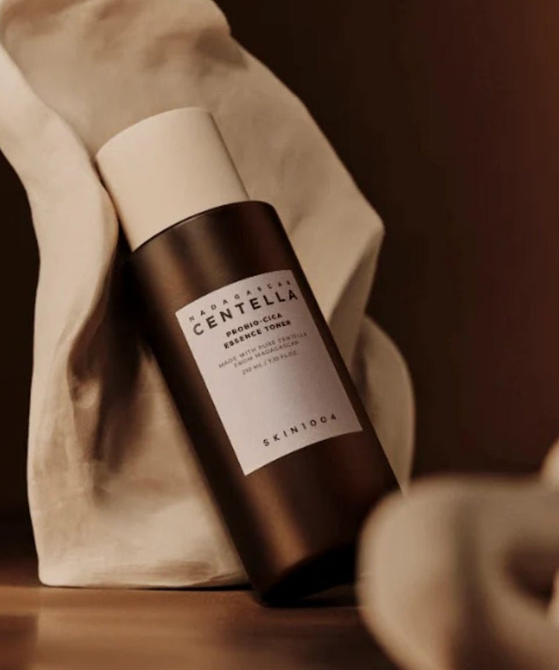 SKIN1004 Madagascar Centella Probio-cica Essence Toner 210ml en bouteille sombre sur fond naturel en tissu blanc