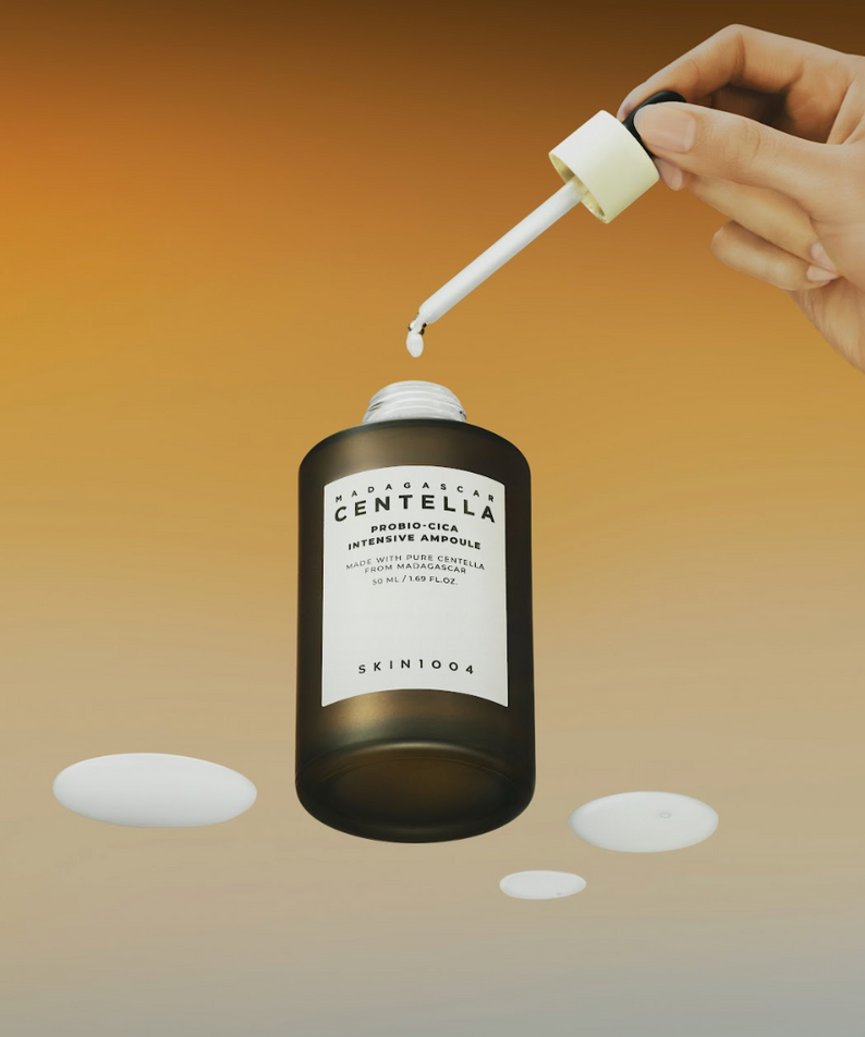 Ampoule SKIN1004 Madagascar Centella Probio-cica Intensive 95ml, application avec pipette, fond ombré orange.