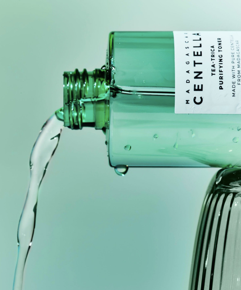 SKIN1004 Madagascar Centella Tea-trica Purifying Toner 210ml versé, tonifiant purifiant sur fond vert elegant.