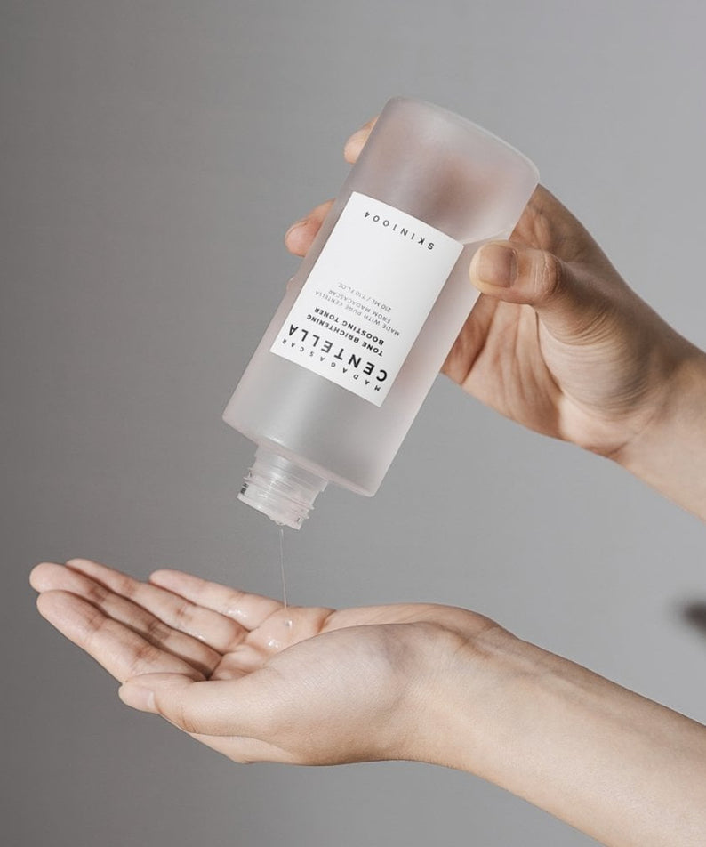 SKIN1004 Madagascar Centella Tone Brightening Boosting Toner 210ml versé dans une main pour soin visage.