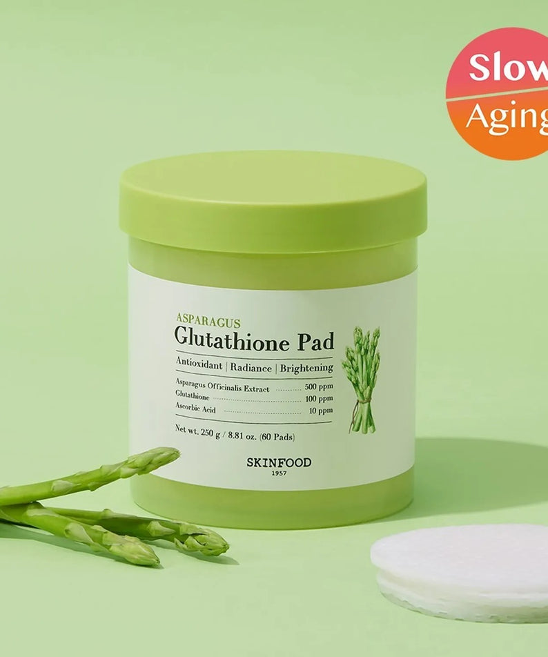 SKINFOOD Asparagus Glutathione Pad (60 Pads) de la marque SKINFOOD, sur fond vert avec gants et cœurs d’asperge.