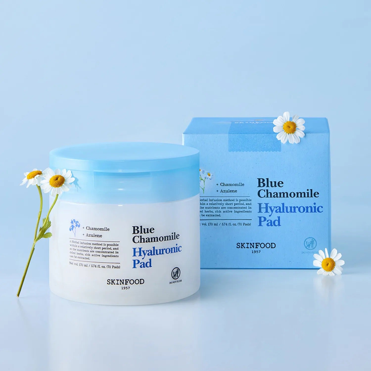 SKINFOOD Blue Chamomile Hyaluronic Gel Pads 70 Sheets, pots et boîte bleue avec fleurs de camomille sur fond clair.