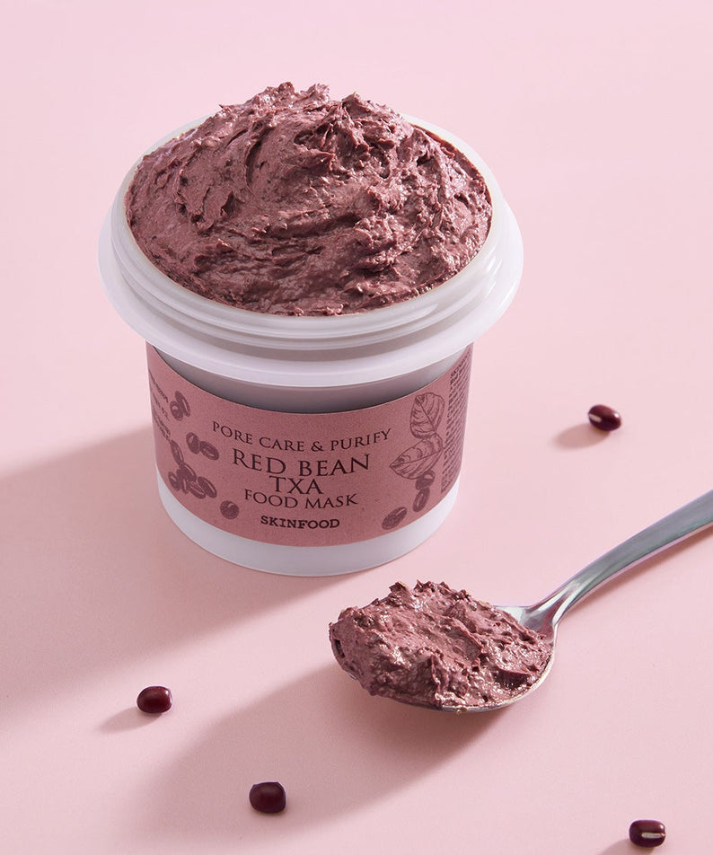 Décris l'image en français : pot SKINFOOD Red Bean Tranexamic Acid Food Mask 120g, texture crème violette sur fond rose.