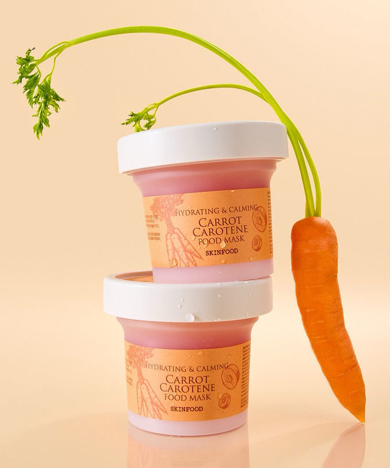 Deux pots de SKINFOOD [NEW ] Carrot Food Mask 120g empilés avec une carotte entière, sur fond beige.