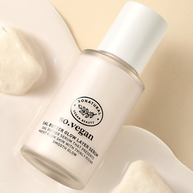 SO NATURAL Sal Butter Blending Serum 50ml, flacon crème en contexte spa minimaliste, marque SO NATURAL, mains en arrière-plan.