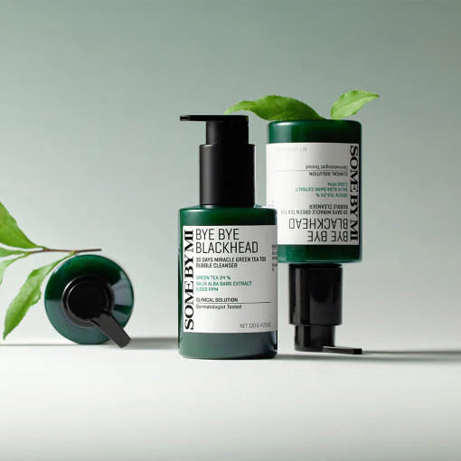 SOME BY MI Bye Bye Blackhead Bubble Cleanser 120g, flacons vert et noir sur fond clair, feuilles en contexte soin visage