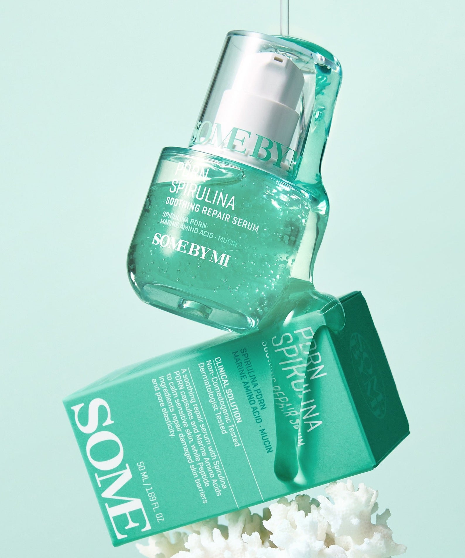 SOME BY MI PDRN Spirulina Soothing Repair Serum 50ml suspendu sur fond vert pour soin visage, boîte et flacon inclus.