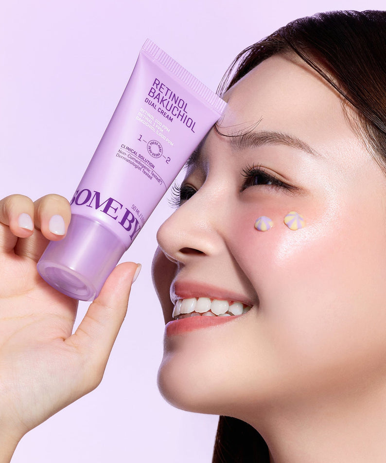 Femme souriante tenant SOMEBYMI Retinol Bakuchiol Dual Cream 50ml devant son visage.