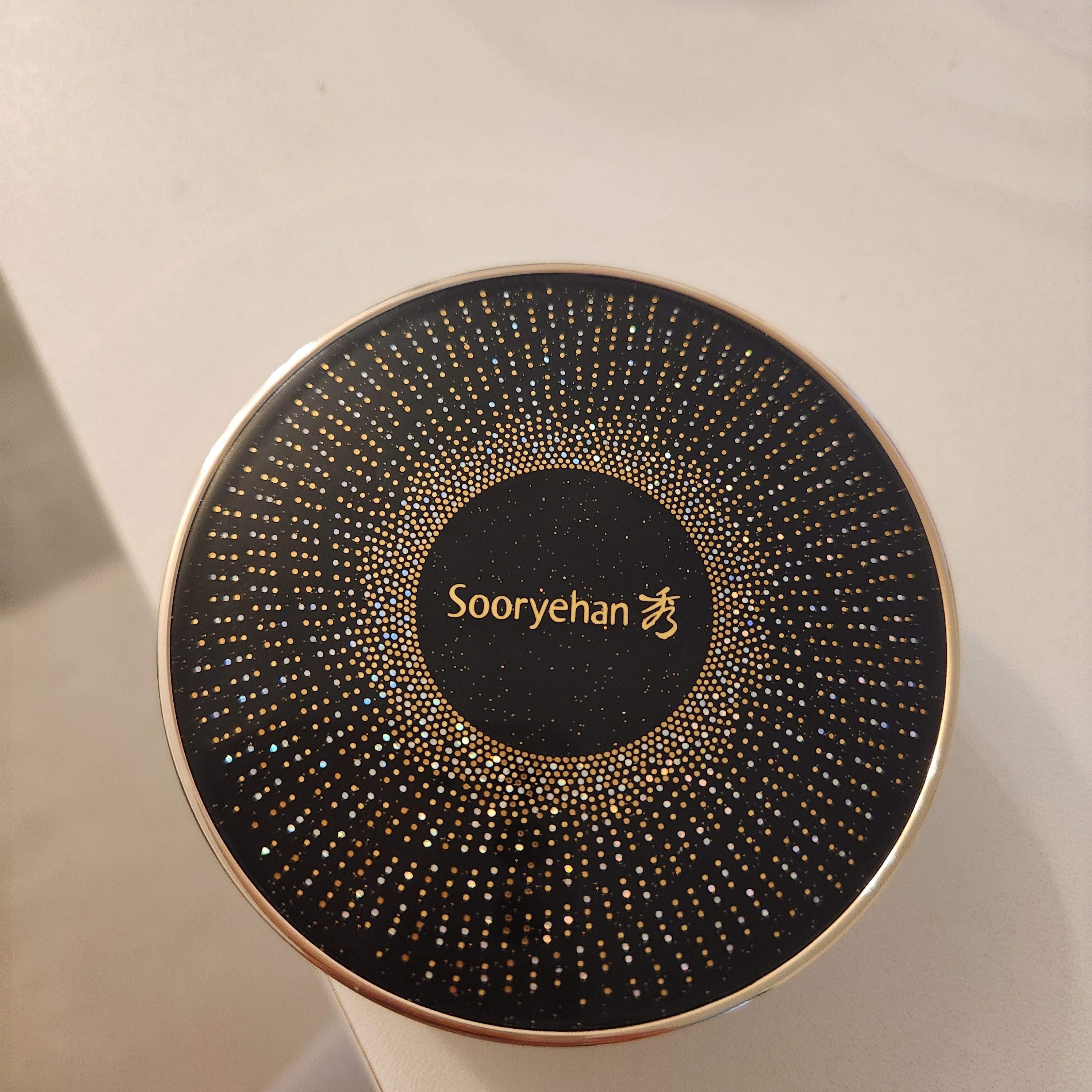SOORYEHAN Beautiful Black Ginseng Cushion Project 15g : pot noir avec motif doré, en vitrine (marque Sooryehan).