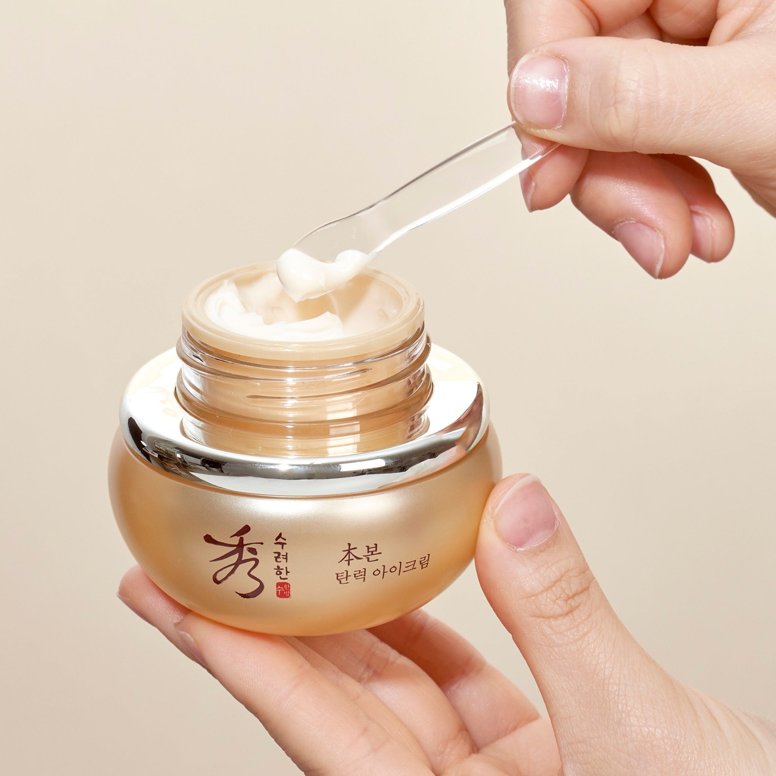 SOORYEHAN Bon Elasticity Eye Cream 25ml, main tenant le pot, crème appliquée sur l’ouverture, contexte soin beauté.